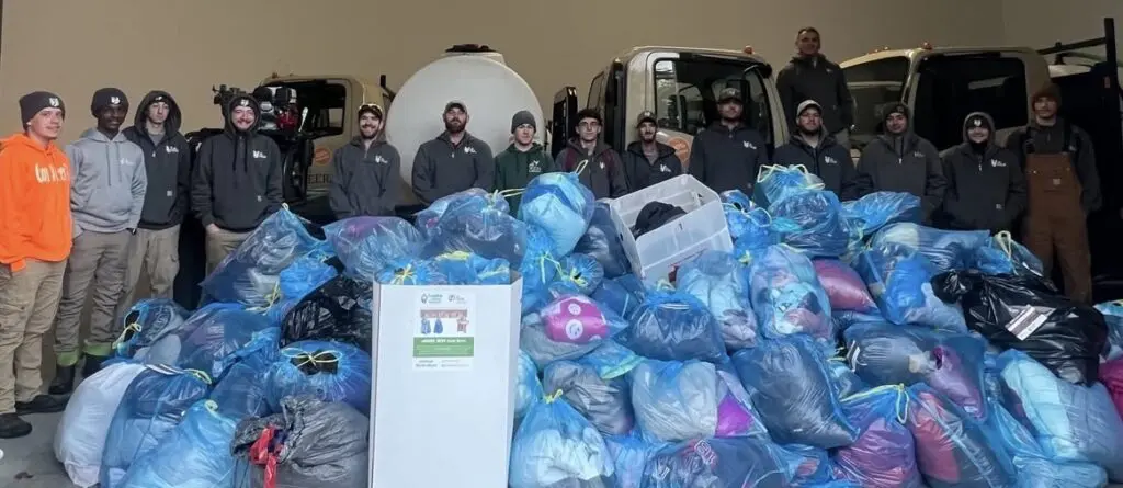ohDEER coat drive, technicians behind pile of coats collected