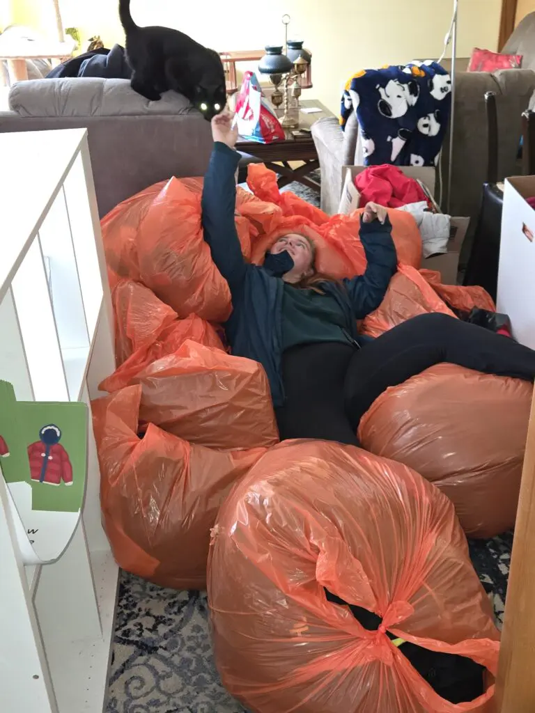 Sarah Lucco laying in coats she collected for coat drive
