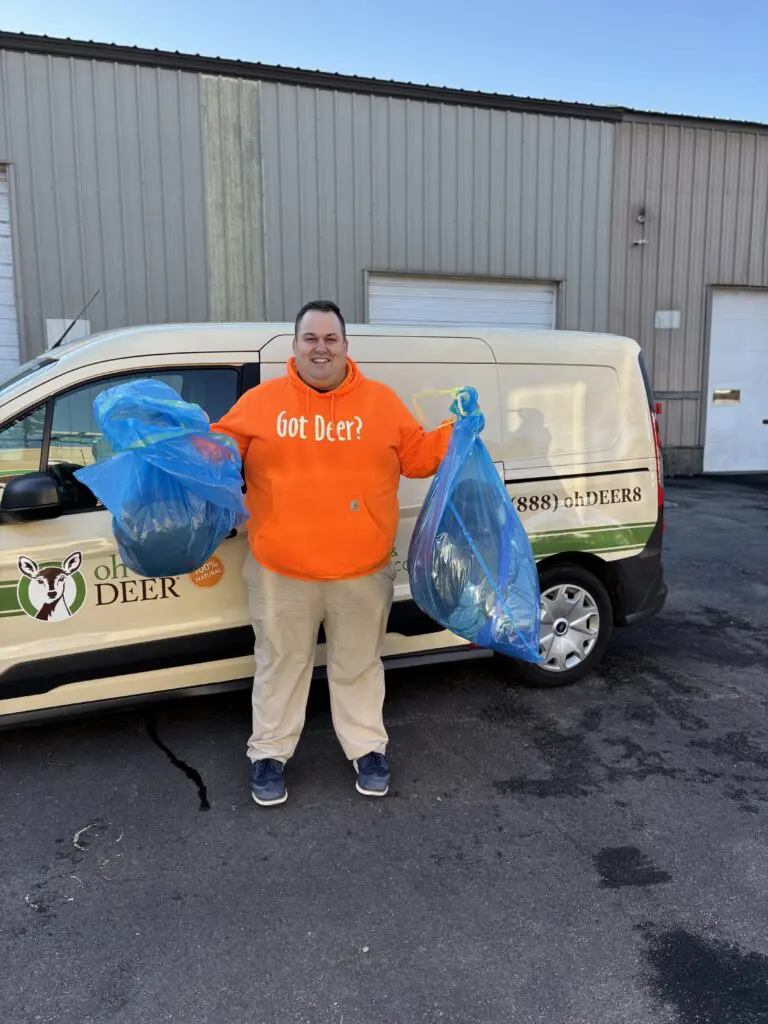 John Avino in orange got deer hoodie in front of deer van with coats from ohDEER coat drive
