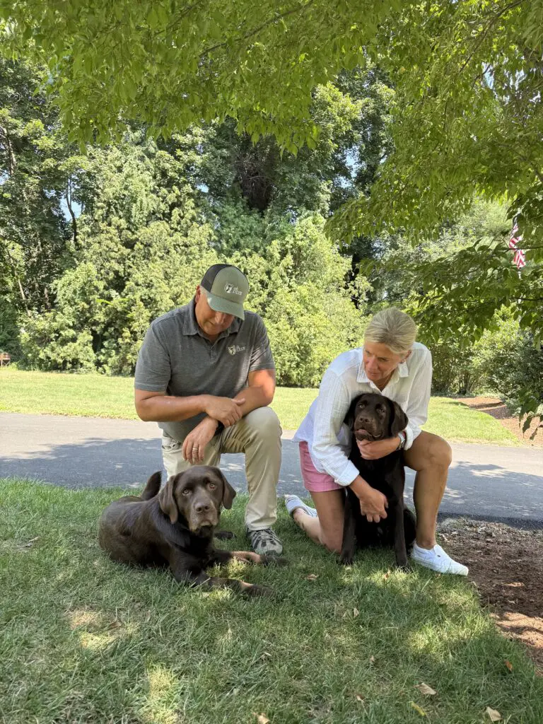 ohDEER founders Kurt and Colleen Upham with their chocolate labs in their yard in massachusetts 