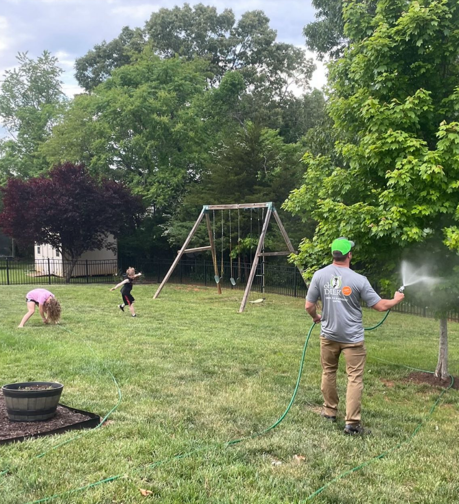 wes hafner spraying his yard while his kids play all natural tick and mosquito control