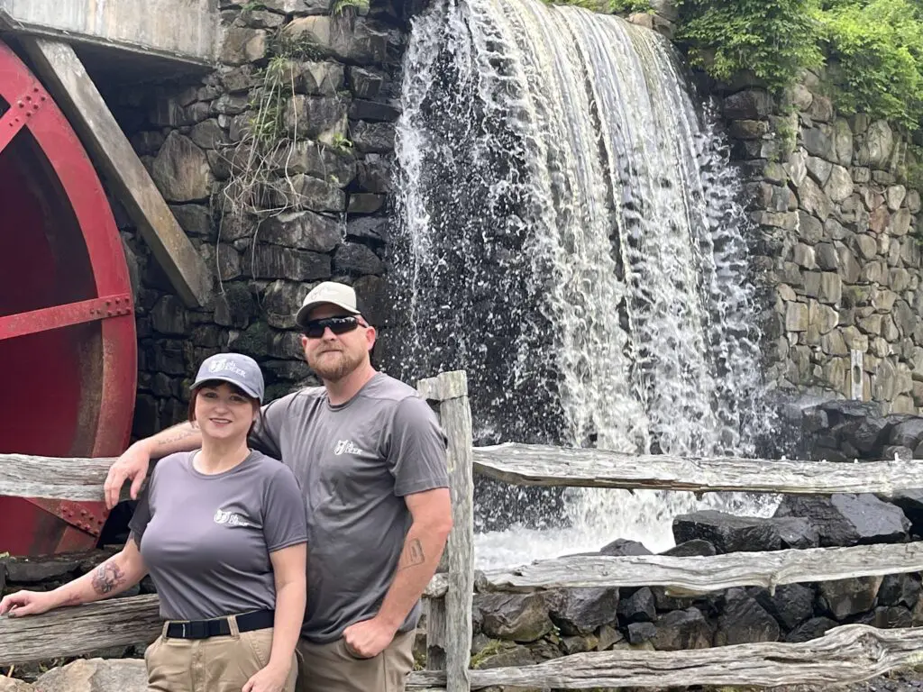 brandi burns and earl neumann in front of waterfall 